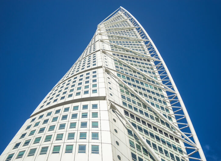A low angle view of the Turning Torso under a blue sky and sunlight in Malmo in Sweden