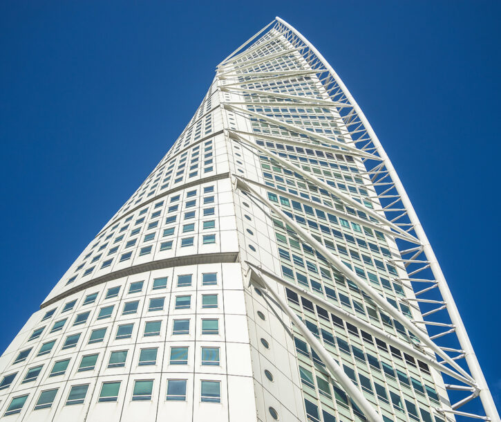 A low angle view of the Turning Torso under a blue sky and sunlight in Malmo in Sweden
